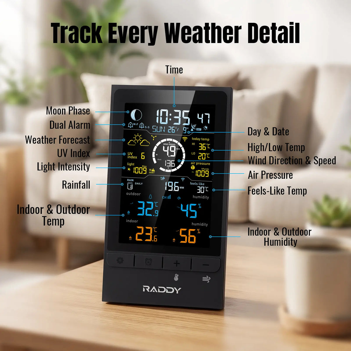 A black RADDY UV7 digital weather dashboard standing on a wooden table in a softly blurred living room setting. The screen displays multiple weather metrics, and white text labels point to various features like moon phase, weather forecast, UV index, rainfall, indoor/outdoor temperature, and humidity.